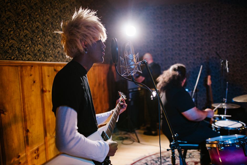 Energetic band practice session with guitarist and drummer performing passionately.