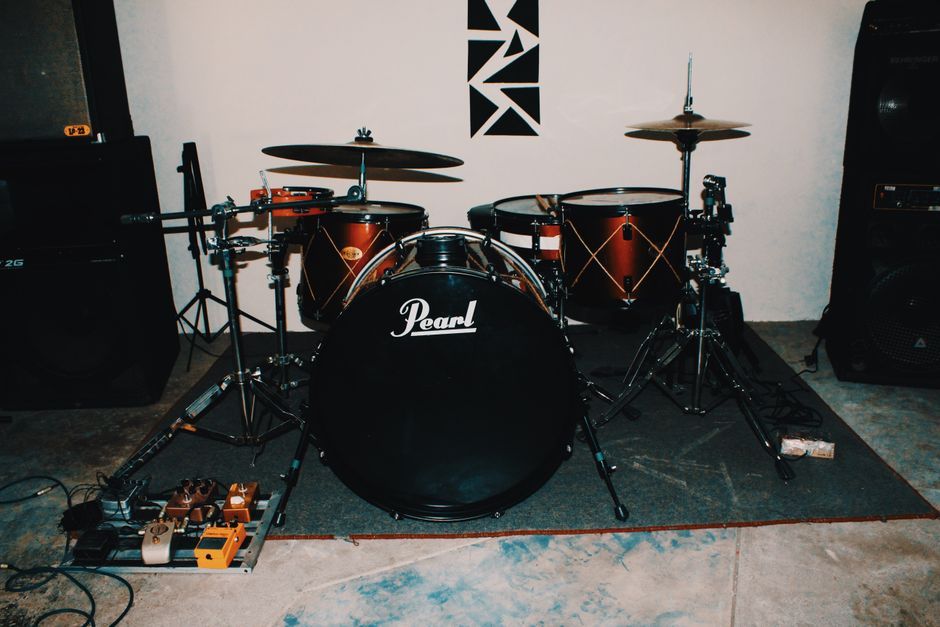 A complete drum set in a music studio showcasing the Pearl bass drum and cymbals.